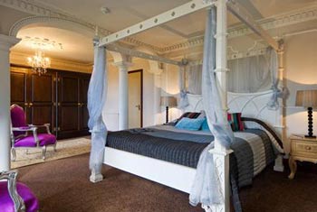 Plush hotel four-poster room Plush hotel four poster bed